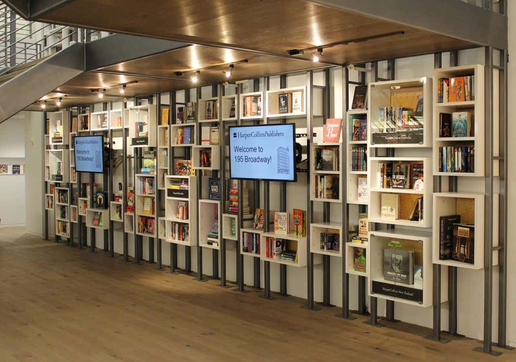 Pictured: an upclose photograph of the lobby exhibit History Factory built for HarperCollins. This shows a series of bookcases featuring authors HarperCollins has published over the decades.